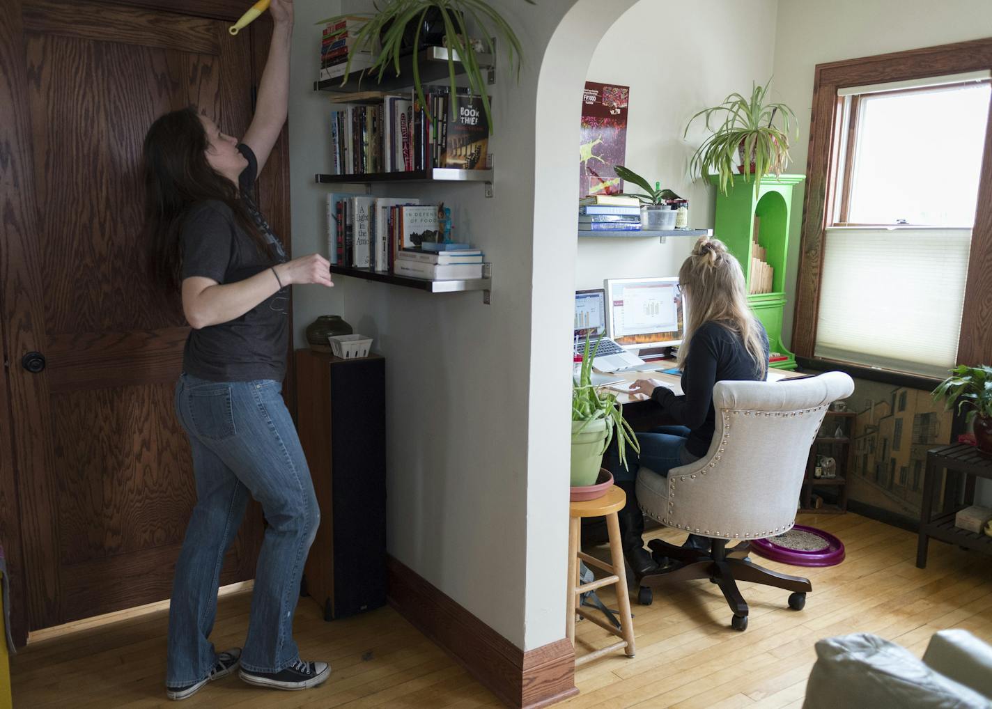 Housekeeper Jennifer Kraskey dusted at the Minneapolis home of U cancer researcher and Ph.D. student Emily Pomeroy, who used the time to catch up on e-mails.