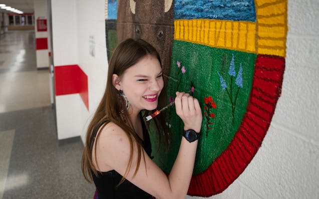 Lexi Sanburg works on the mural she’s painting in a hallway of Centennial High School in Circle Pines on Thursday.