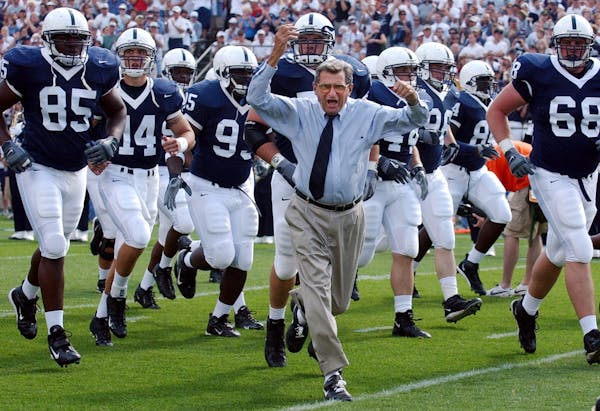 In this Sept. 4, 2004 file photo, Penn State football coach Joe Paterno leads his team onto the field before a game against Akron.
