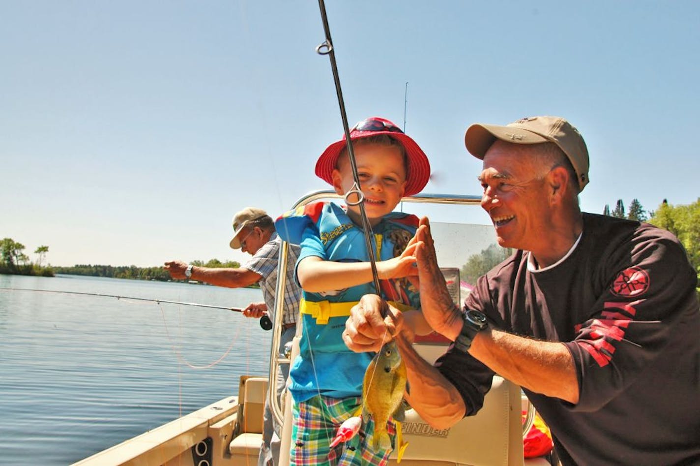 Famed angler Larry Dahlberg, right, congratulated his grandson, Vaughn Weber, 4, on a sunfish catch.