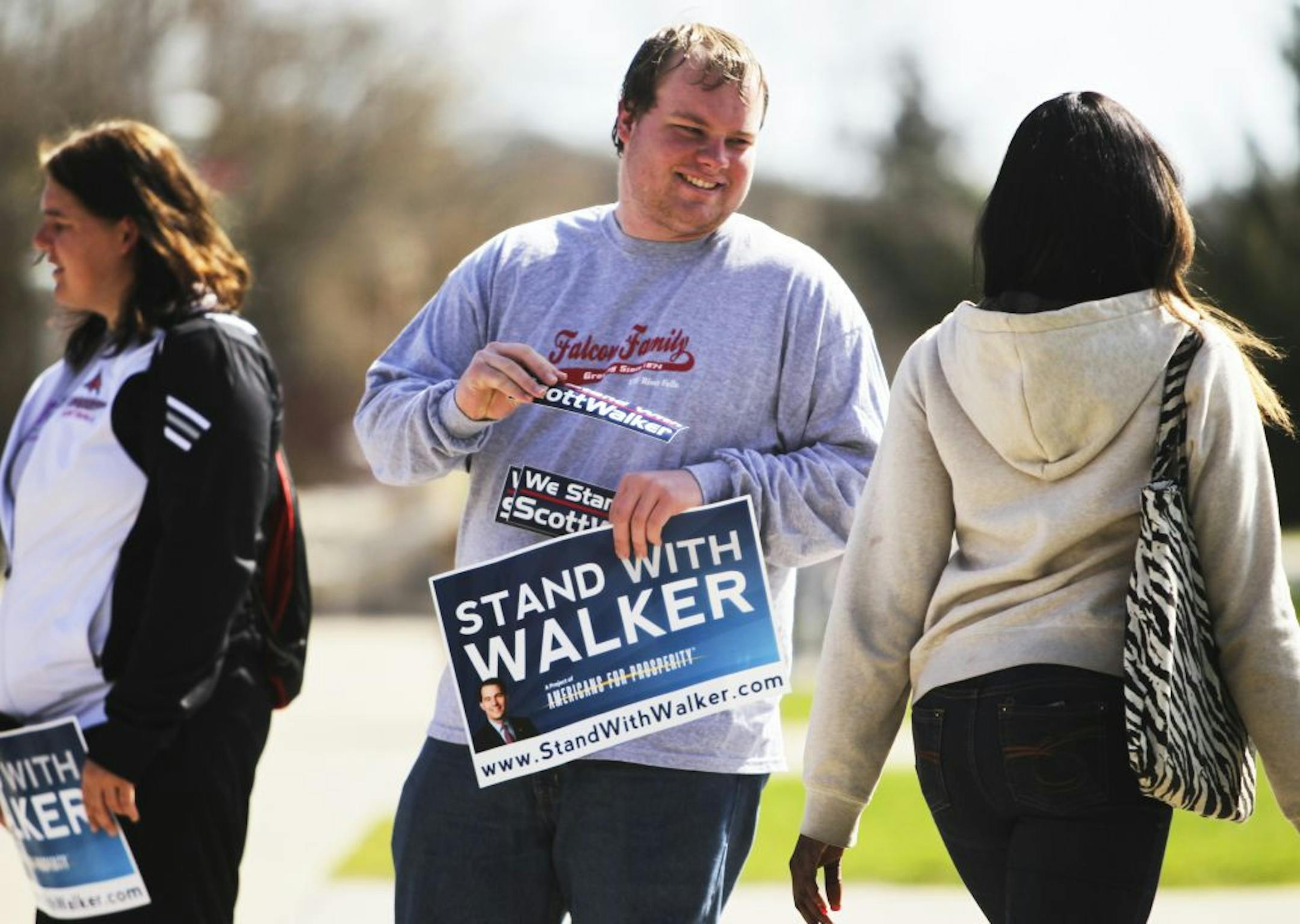 Senior Carlan Strand of Blooming Prairie, MN, joined fellow college Republicans standing in the center of the University of Wisconsin-River Falls campus to hand out pro-Gov. Scott Walker bumper stickers while holding signs in River Falls, WI, Wednesday, April 4, 2012.