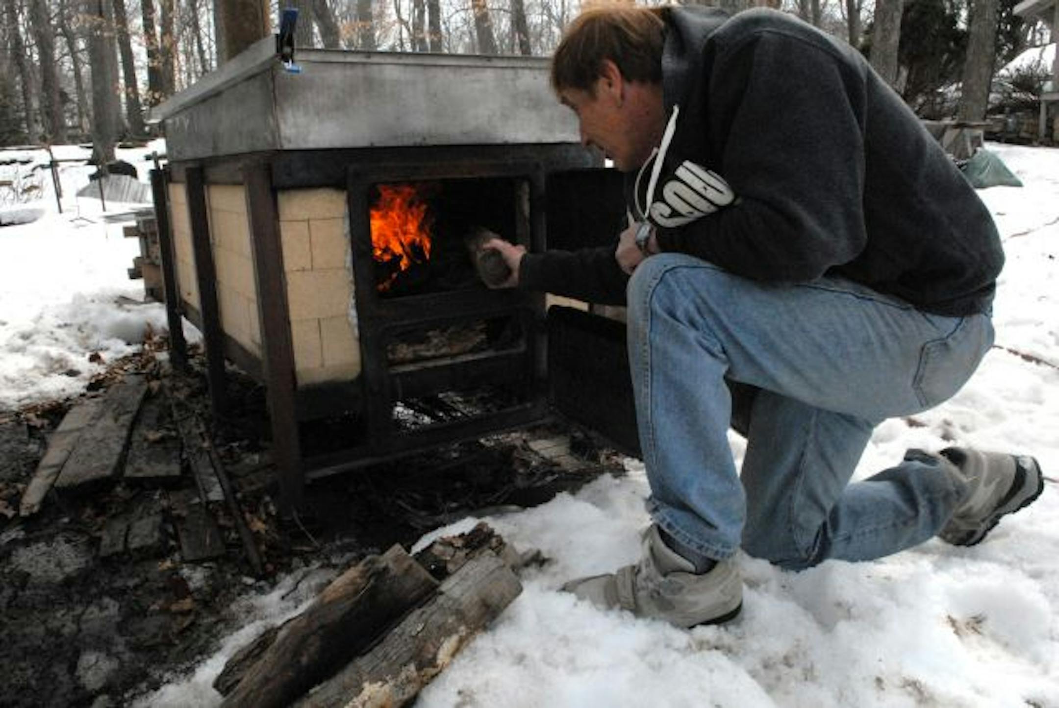 Lon Navis stokes the cooker he uses each spring to boil sap into maple syrup. Navis and his neighbors boil 300 gallons or more of sap.