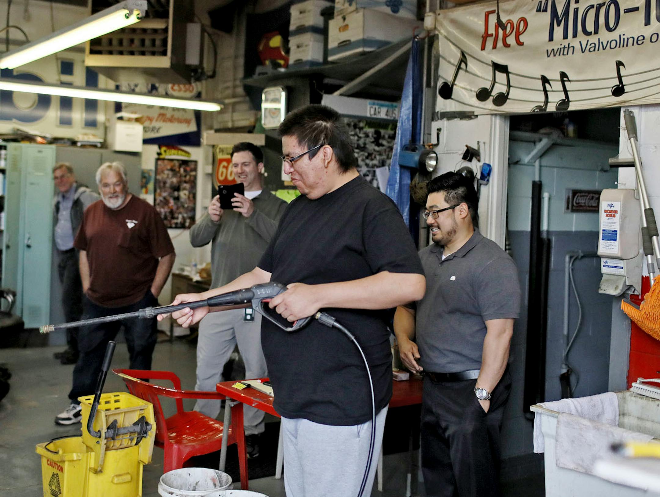 Ian Little Cloud, handles a washing wand during the try out as his coaches and the garage workers look on Wednesday, May 9, 2018, in St. Paul, MN.