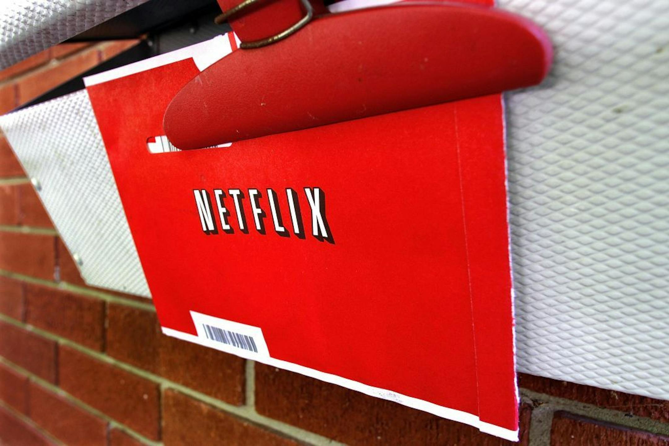 FILE - In this Thursday, Aug. 23, 2012, file photo, a Netflix envelop containing a DVD to be returned by mail is clipped onto a mailbox, in Springfield, Ill. Netflix won�t miss Saturday mail delivery, even though the weekend service helped keep its DVD-by-mail subscribers happy. The U.S. Postal Service�s planned shift to five days of home delivery a week instead of six may even make Netflix Inc. slightly more profitable.