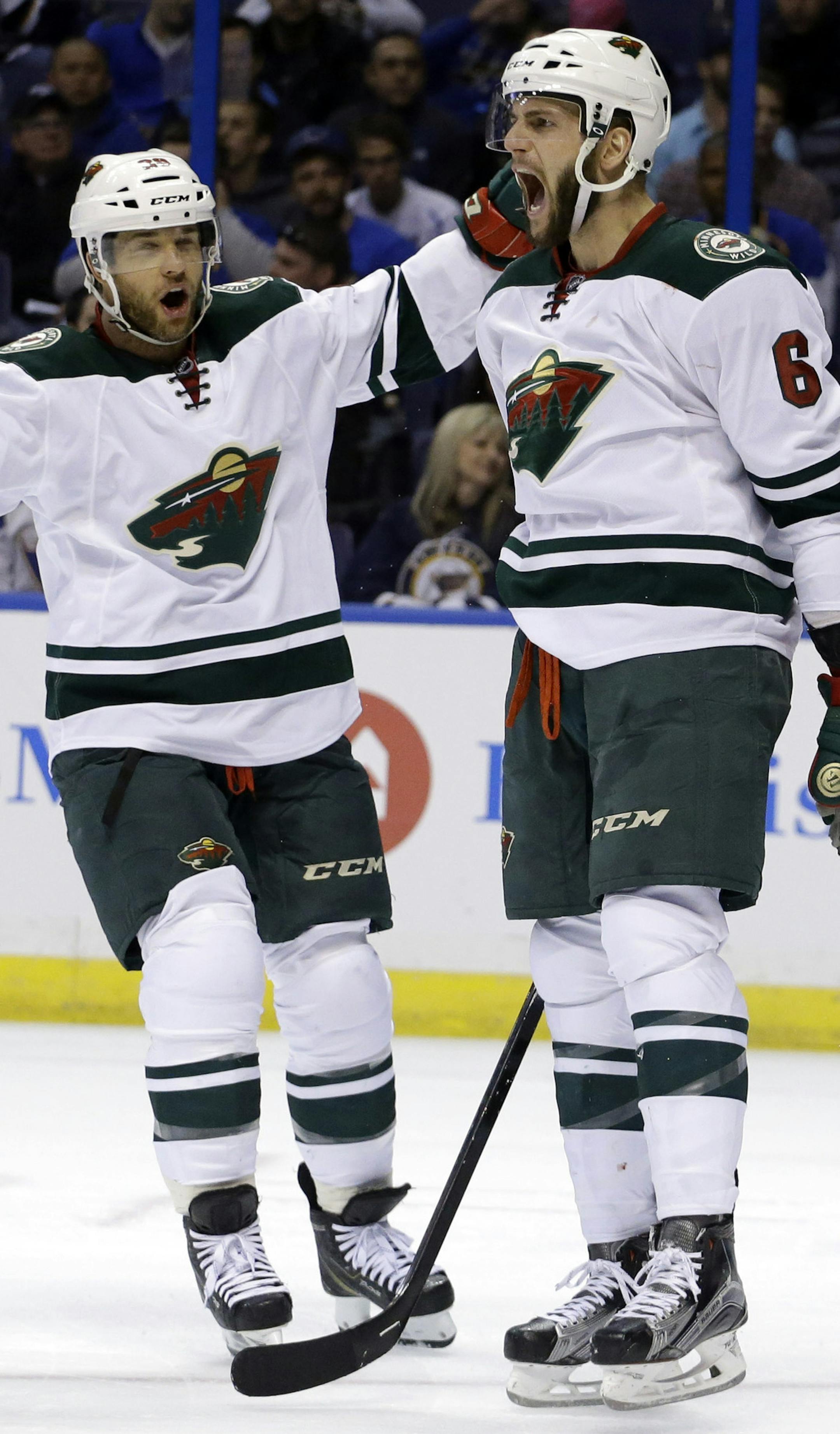 Minnesota Wild's Marco Scandella, right, is congratulated by teammate Jason Pominville after scoring during the first period in Game 5 of an NHL hockey first-round playoff series against the St. Louis Blues, Friday, April 24, 2015, in St. Louis. (AP Photo/Jeff Roberson)