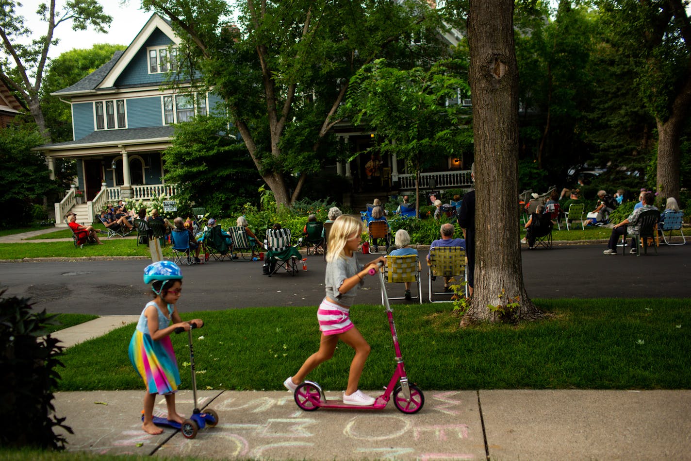 [A front yard performance by guitarist Pat Donohue of "Praire Home Companion" was hosted at Dick CohnÕs home in St. Paul Friday, August 7, 2020. NICOLE NERI ¥ Special to the Star Tribune] Children ride their scooters over a sidewalk message reading ÒWelcome MusiciansÓ across the street from a front yard performance by guitarist Pat Donohue of "Praire Home Companion" at Dick CohnÕs home in St. Paul Friday, August 7, 2020.