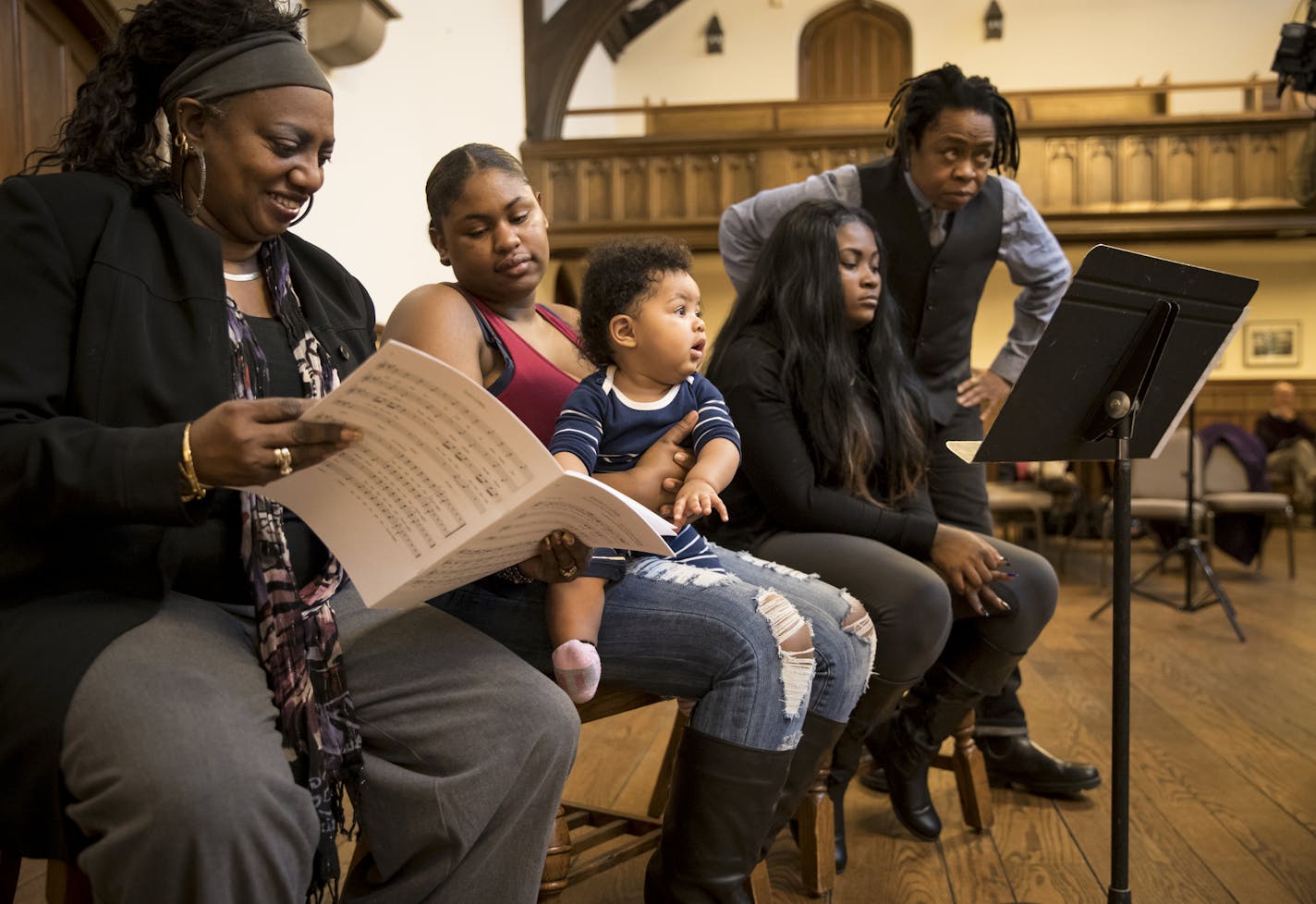 Amina Caver pointed to the music while sitting on her mother Arianna Caver's lap. They were listening to a song for the first time written by Tristiana Coffee, right, about her daughter Ivory. Behind her stood guest artist Melanie DeMore. They were all part of the "Lullaby Project" at Plymouth Congressional Church on Tuesday, January 10, 2016, in Minneapolis, Minn. At left is Geneva Dorsey, high school dean. ] RENEE JONES SCHNEIDER &#x2022; renee.jones@startribune.com