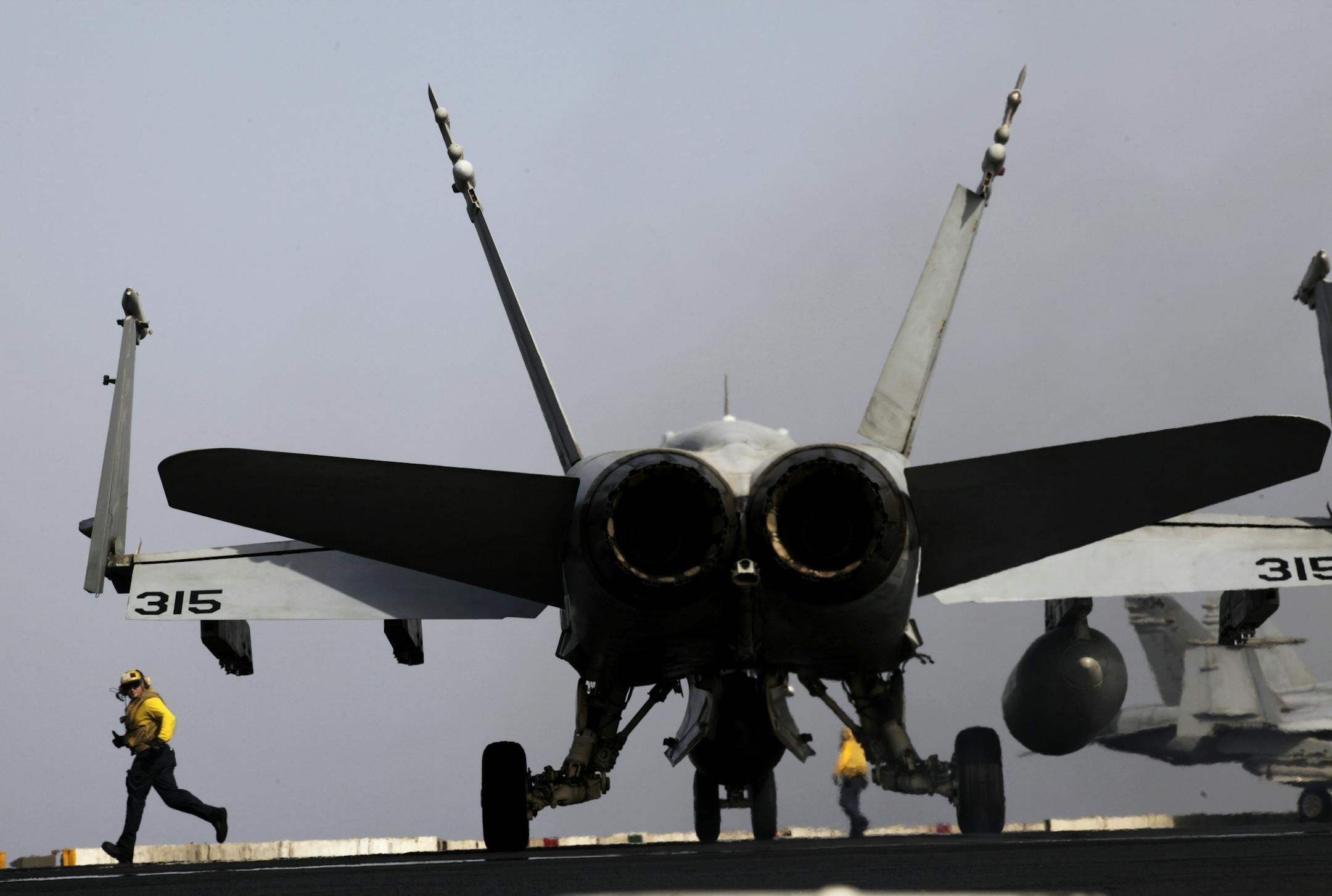In this Aug. 10, 2014 photo, U.S Navy sailors prepare an aircraft for missions targeting the Islamic State group in Iraq from the deck of the U.S. Navy aircraft carrier USS George H.W. Bush in the Persian Gulf. Combined U.S.-Arab airstrikes at the heart of the Islamic State group's military strongholds in Syria achieved their strategic aim of showing the extremists that their savage attacks will not go unanswered, the top American military officer said Tuesday, Sept. 23, 2014.
