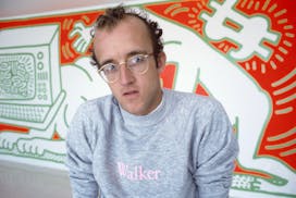 Keith Haring poses in 1984 with the orange-and-white mural he painted at the Walker Art Center to commemorate the completion of the then-new undergrou