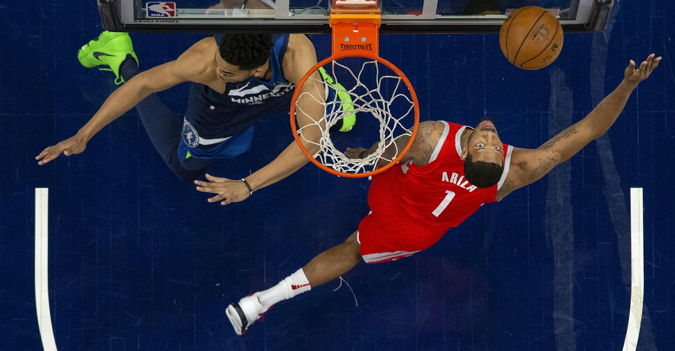 Trevor Ariza (1) attempted a shot while being defended by Karl-Anthony Towns (32) in the first half.