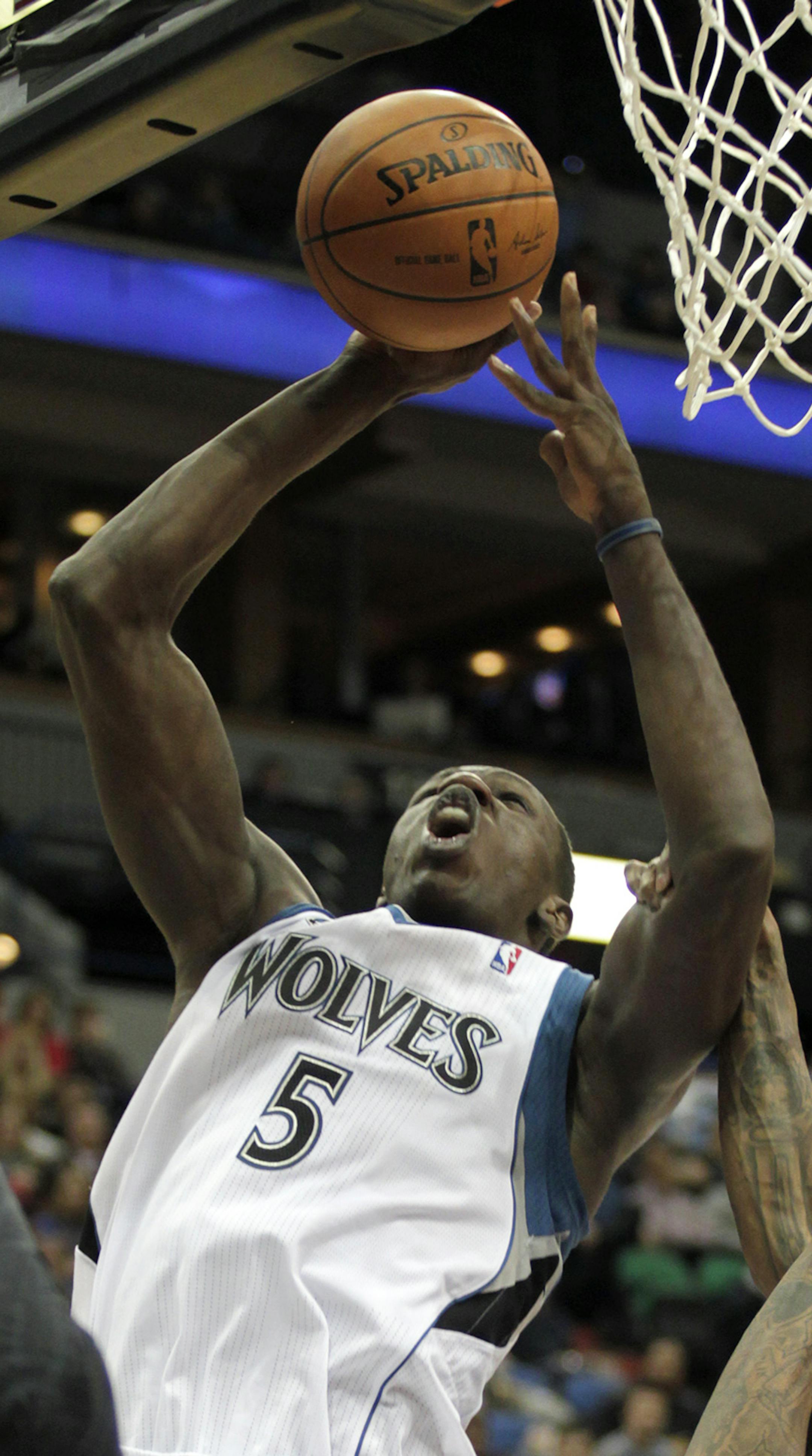 Minnesota Timberwolves center Gorgui Dieng (5) puts up a shot over Atlanta Hawks guard Louis Williams (3) during the second half of an NBA basketball game, Wednesday, March 26, 2014, in Minneapolis. Dieng had 15 points and 15 rebounds on the night as Minnesota won 107-83. (AP Photo/Paul Battaglia)