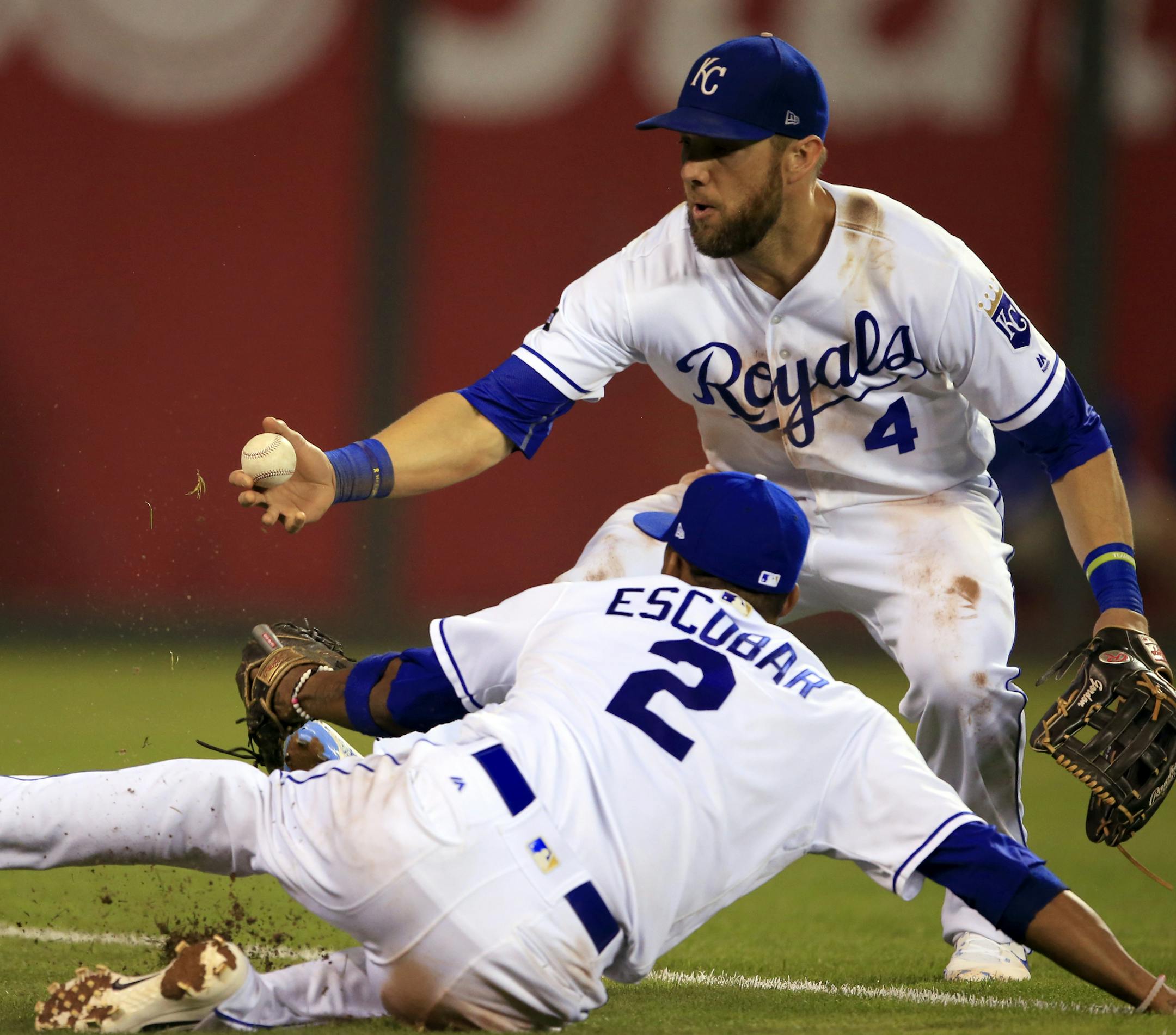 Kansas City Royals left fielder Alex Gordon (4) grabs a ball hit by Minnesota Twins' Jason Castro, next to shortstop Alcides Escobar (2), during the ninth inning of a baseball game at Kauffman Stadium in Kansas City, Mo., Thursday, Sept. 7, 2017. The Twins defeated the Royals 4-2. (AP Photo/Orlin Wagner)
