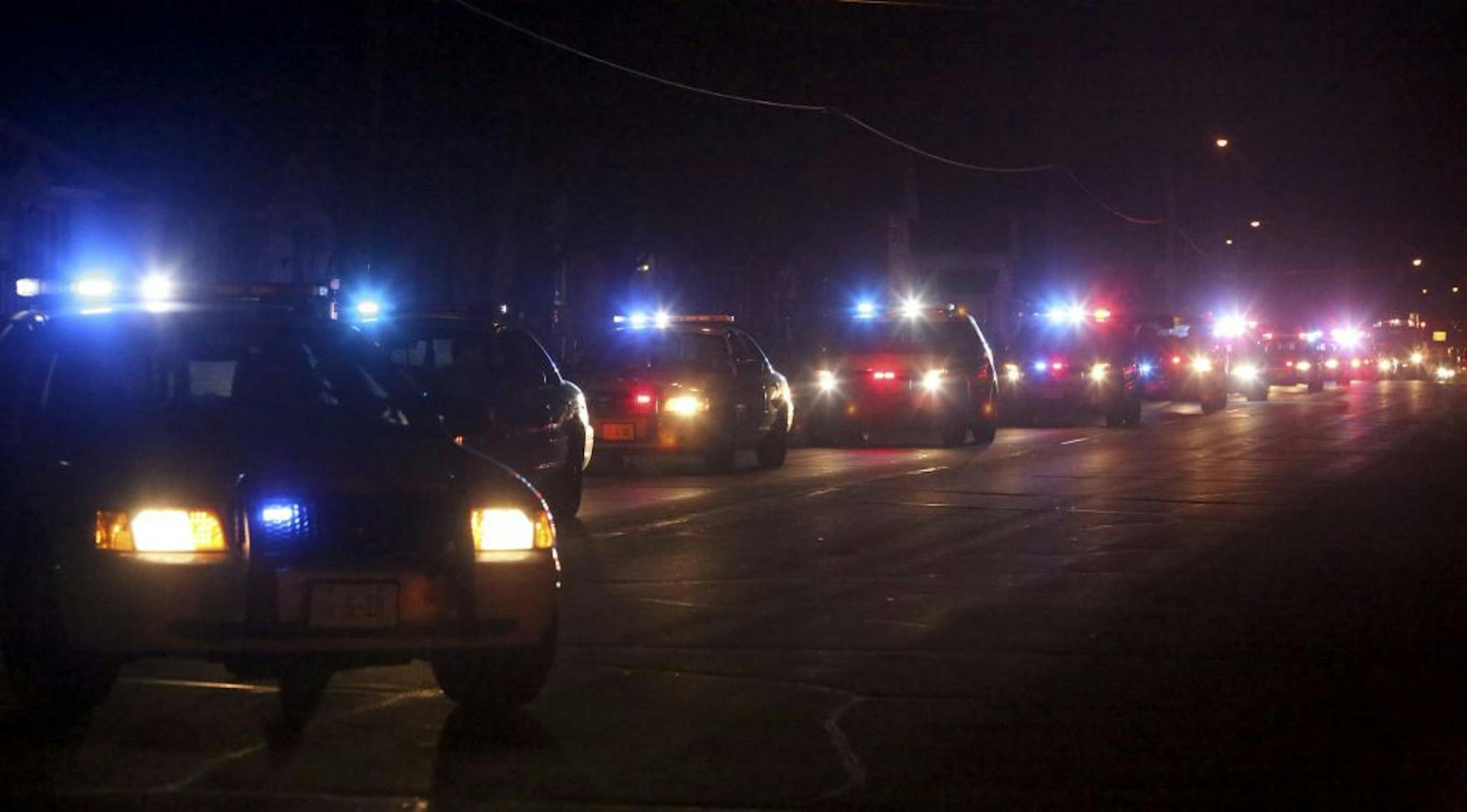 Police and sheriff vehicles followed behind the hearse carrying the body of fallen police officer Tom Decker to the funeral Wenners Funeral home in Cold Spring, Min., Friday November 30, 2012. Decker was fatally shot late Thursday allegedly by Ryan Michael Larson.