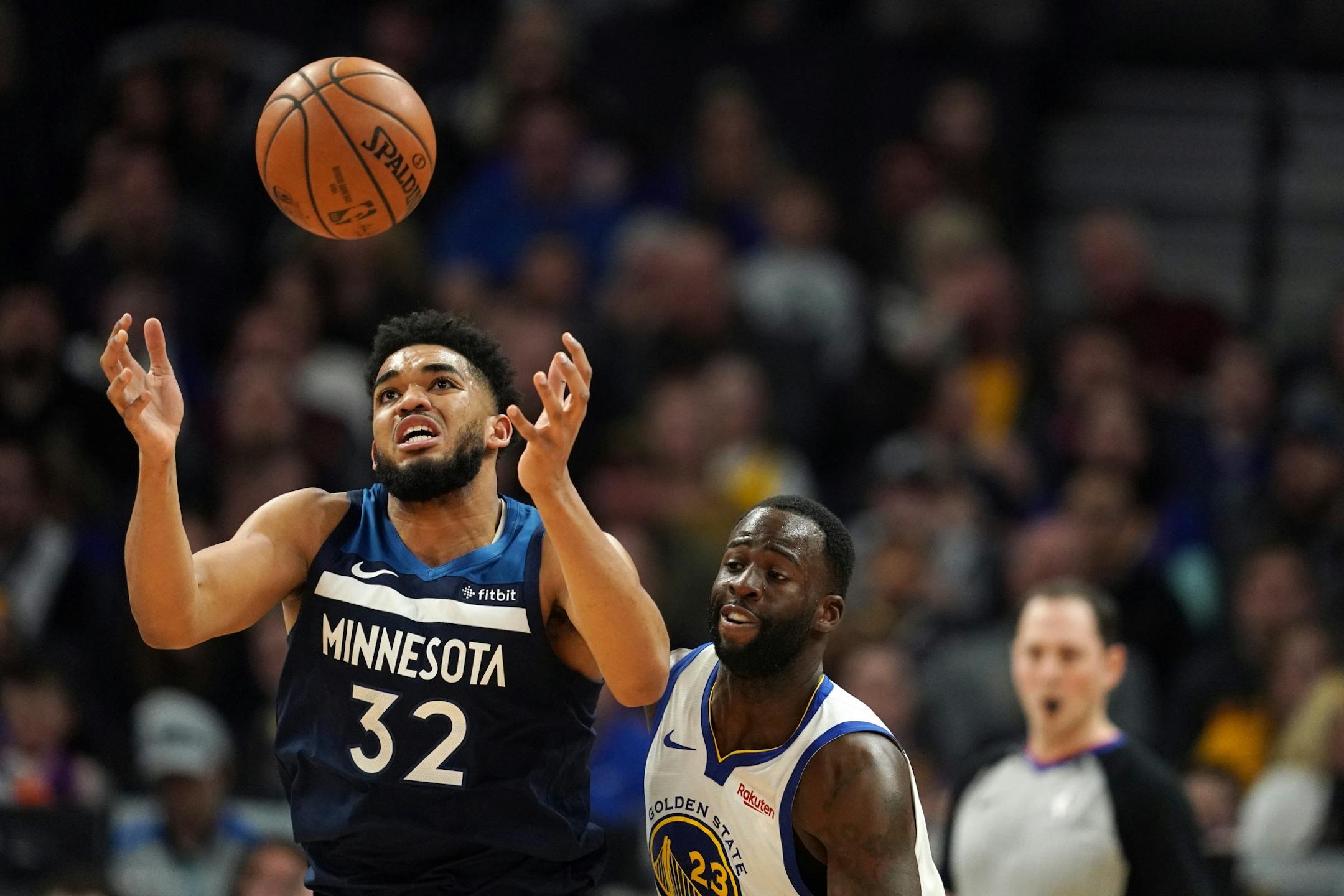 Minnesota Timberwolves center Karl-Anthony Towns (32) tried to grab a loose ball as Golden State Warriors forward Draymond Green (23) looked on in overtime.