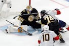 The Panthers' Aleksander Barkov (16) scores against the Bruins' Jeremy Swayman (1) as Bruins' Jake DeBrusk (74) defends during the third period Sunday