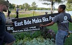 Minneapolis Park and Recreation Board (MPRB) workers install new placards changing East and West Lake Calhoun Parkways to East and West Bde Maka Ska P