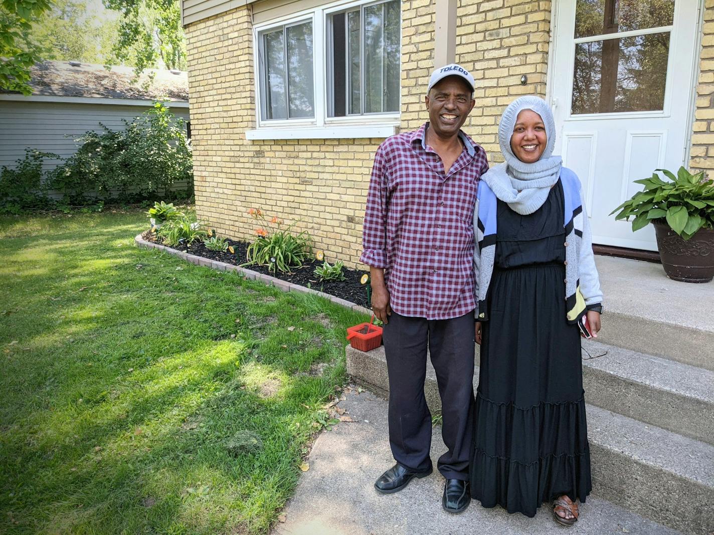 St. Cloud residents Youssouf "Joe" Omar and Hamdia Mohamed stand by a duplex they own as part of their business, Victory Plus Housing, which provides sober living and reasonable rent for people who want to turn their lives around. (Credit: Jenny Berg)