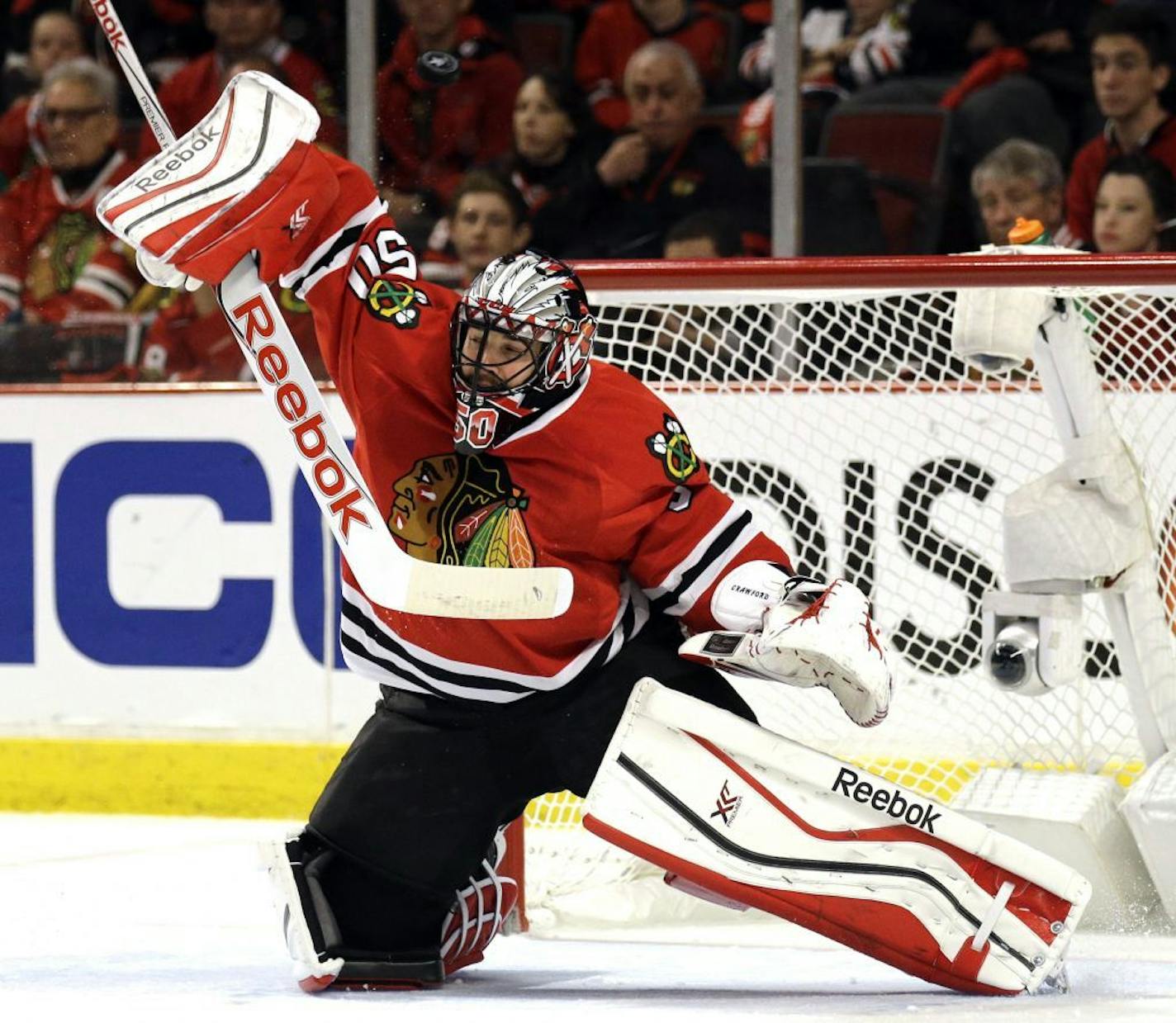 Chicago Blackhawks goalie Corey Crawford blocks a shot against the Minnesota Wild during the first period of Game 2 in the second round of the NHL Stanley Cup hockey playoffs in Chicago, Sunday, May 3, 2015.