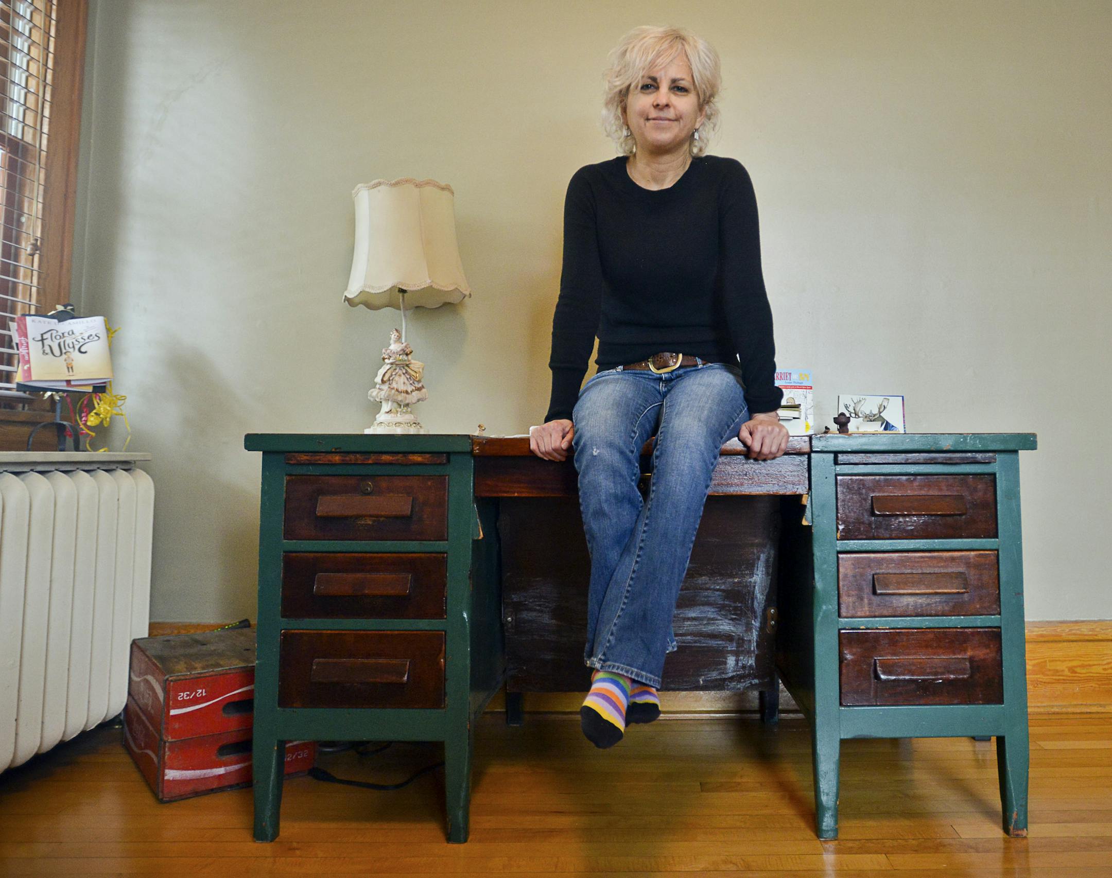 Kate DiCamillo, a Newbery Prize winning author who wrote &#x201a;&#xc4;&#xfa;Because of Winn-Dixie,&#x201a;&#xc4;&#xf9; sits on a writing desk at her home in Minneapolis, Dec. 20, 2013. DiCamillo is being chosen to serve as the fourth national ambassador for young people&#x201a;&#xc4;&#xf4;s literature, a two-year position that promotes reading through appearances across the nation. (Ben Garvin/The New York Times)