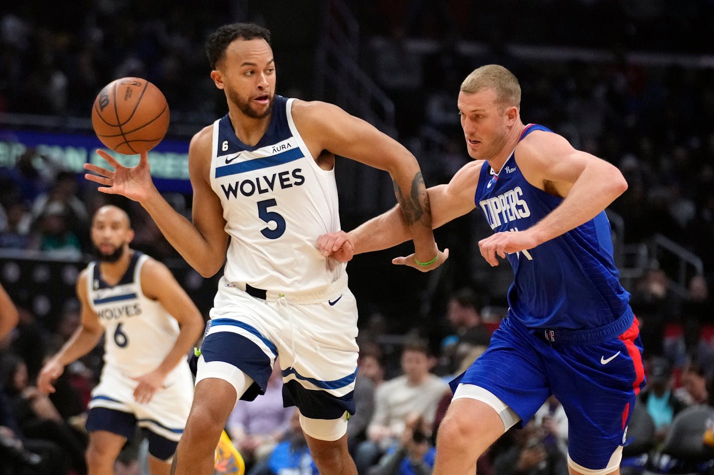 Timberwolves forward Kyle Anderson, left, reaches for the ball next to Los Angeles Clippers center Mason Plumlee