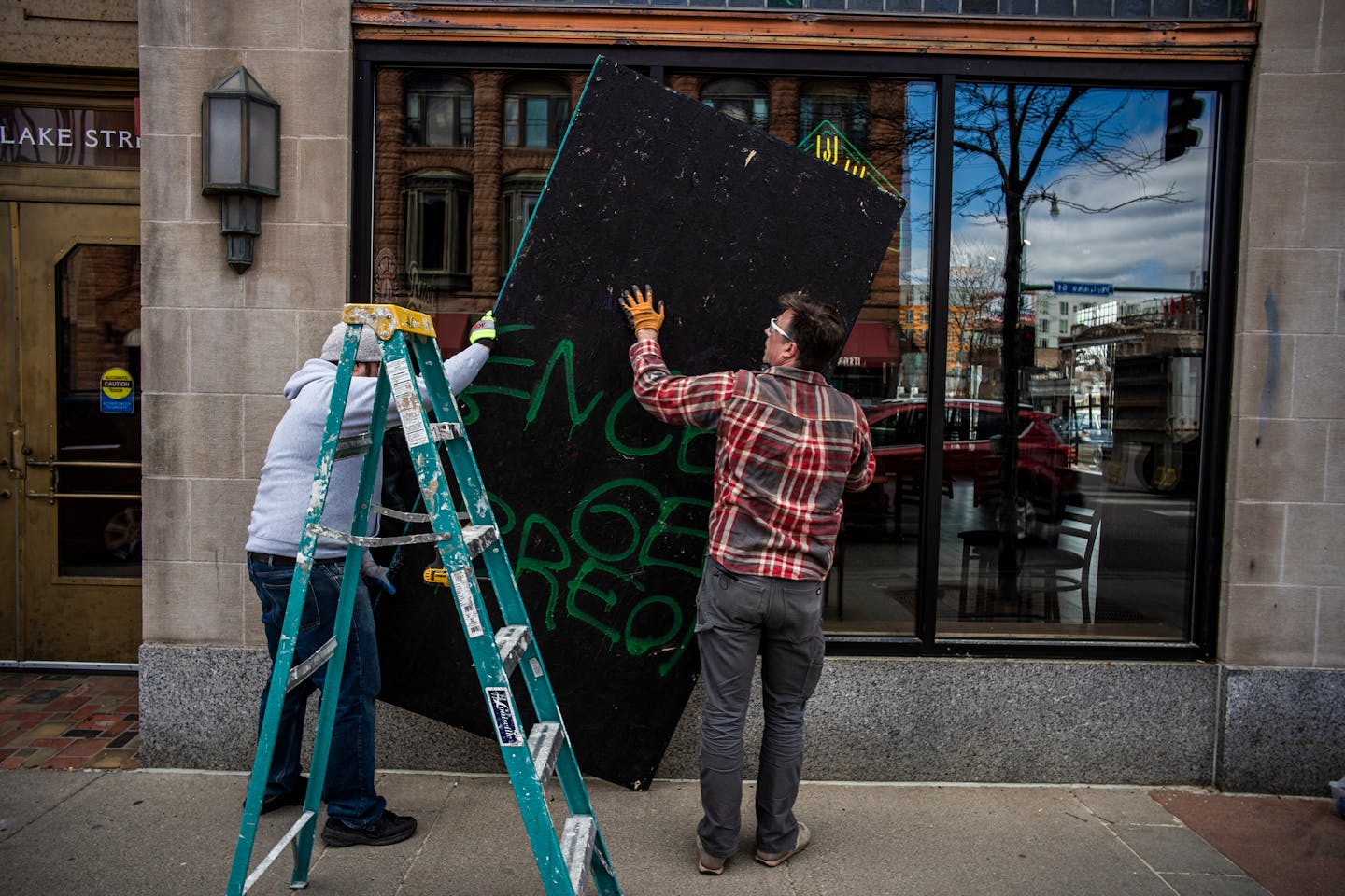 Dan Fehrenkamp(gray) and John Pemble, owners of the Iron Door Pub in Uptown Minneapolis took down their plywood on Wednesday, April 21, 2021. They planned to reopen today after being closed yesterday. The National Guard kept an eye on businesses a day after Derek Chauvin was convicted for the murder of George Floyd.] RICHARD TSONG-TAATARII ¥ Richard.Tsong-Taatarii@startribune.com