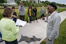 Artist Seitu Jones, right, joins a tour group to talk about "Harriet Robinson Scott" from the series "Shadows at the Crossroads" during the public unv