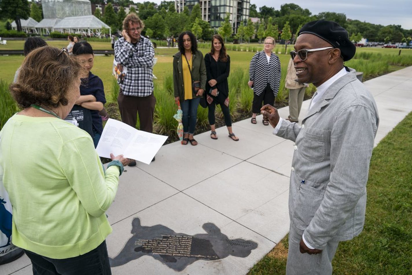 Artist Seitu Jones, right, joins a tour group to talk about "Harriet Robinson Scott" from the series "Shadows at the Crossroads" during the public unveiling.