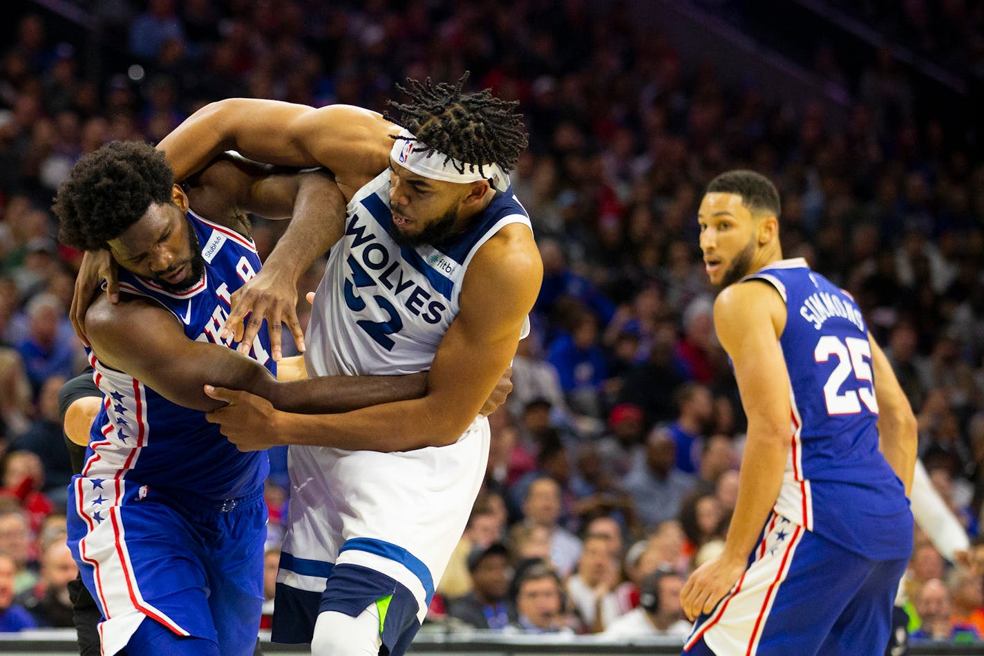 Philadelphia's Joel Embiid, left, fights with the the Timberwolves' Karl-Anthony Towns as Ben Simmons looks on in the third quarter at the Wells Fargo Center in Philadelphia.