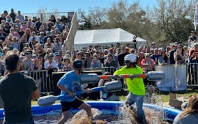 Competitors battled in a muddy pool with weapons made from pool noodles at the Florida Man Games on Saturday, Feb. 24, 2024, in St. Augustine, Fla.