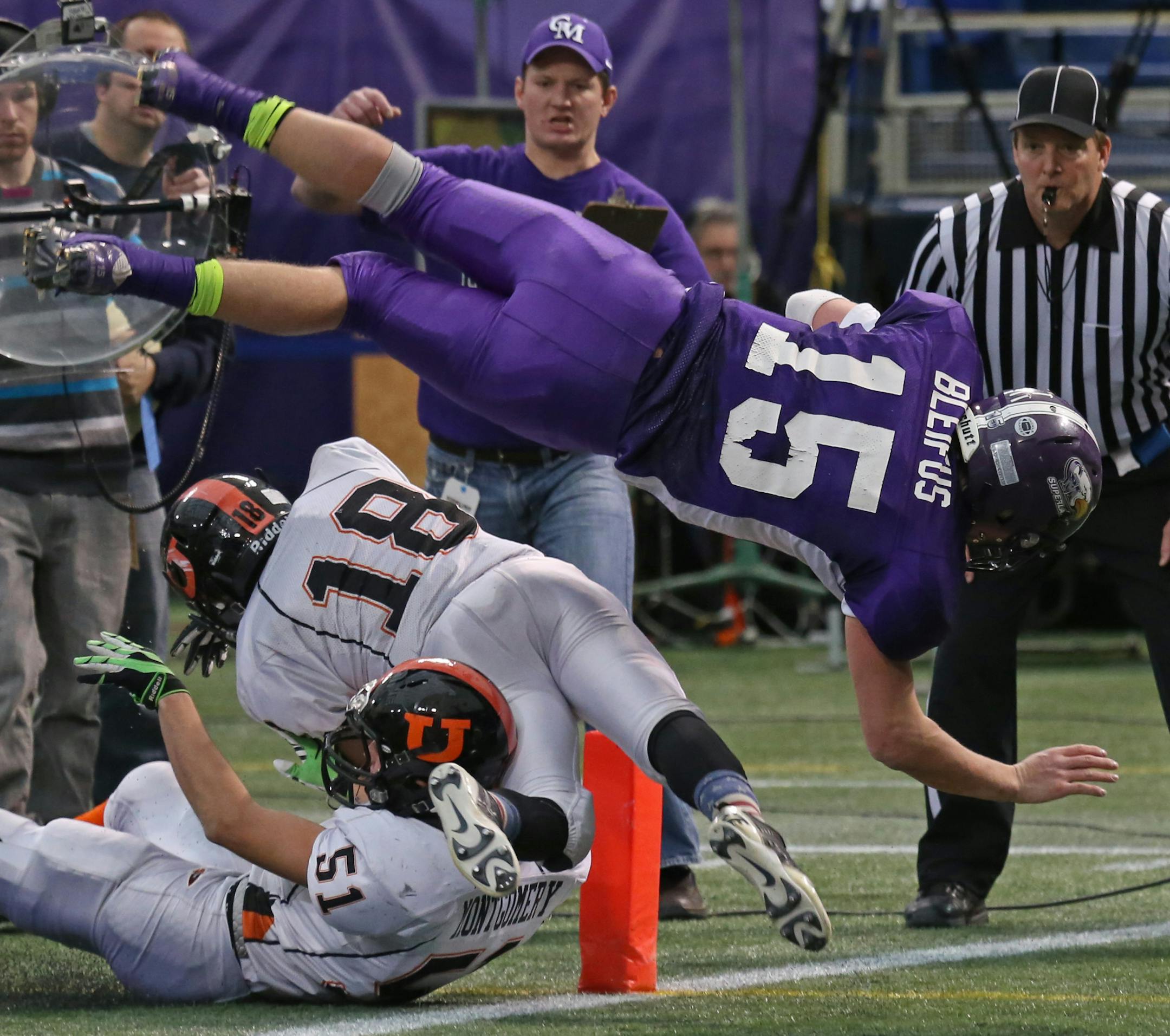 Minnesota State High School League Prep Bowl Championship Games, Metrodome, 11/29/13. Underwood vs. Grand Meadow, 9-Man Championship (left to right) Grand Meadow quarterback Trenton Bleifus jumped over the Underwood defense and into the endzone for the first Superlark touchdown in first half action.] Bruce Bisping/Star Tribune bbisping@startribune.com Trenton Bleifus/roster.