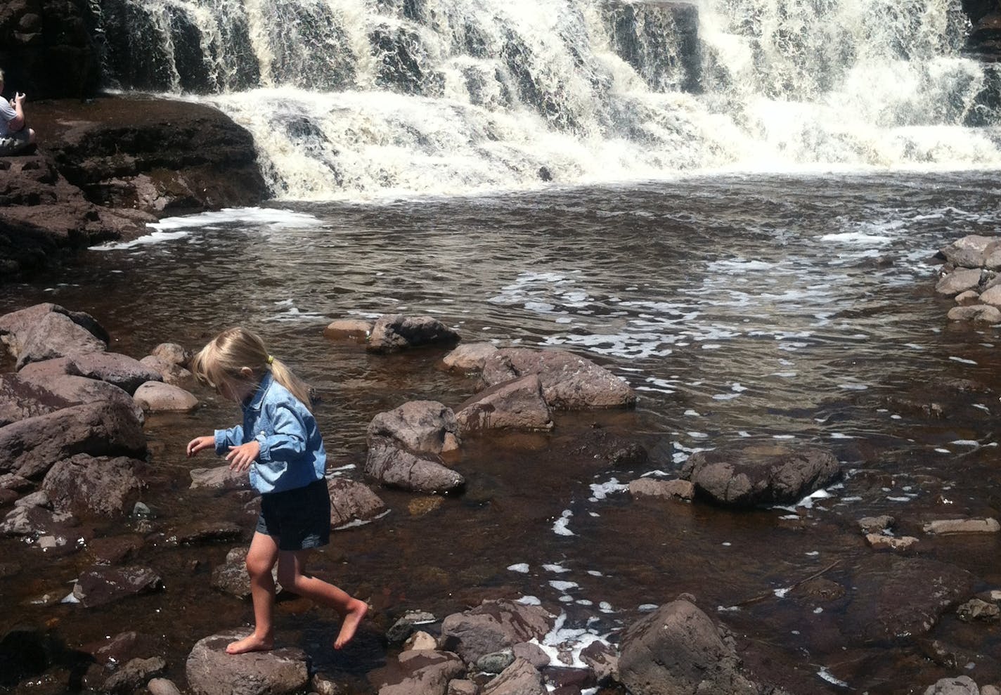 The author's daughter leaped from rock to rock at Gooseberry Falls.