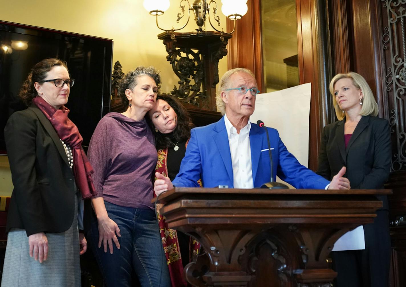 Survivors Laura Stearns and Jina Penn-Tracy rested their heads together at the end of a news conference where attorney Jeff Anderson announced settlements of 16 lawsuits against the Children's Theater Company for sexual abuse in the 1970s and early 1980s. On the right is CTC managing director Kimberly Motes, on the left attorney Molly Burke.