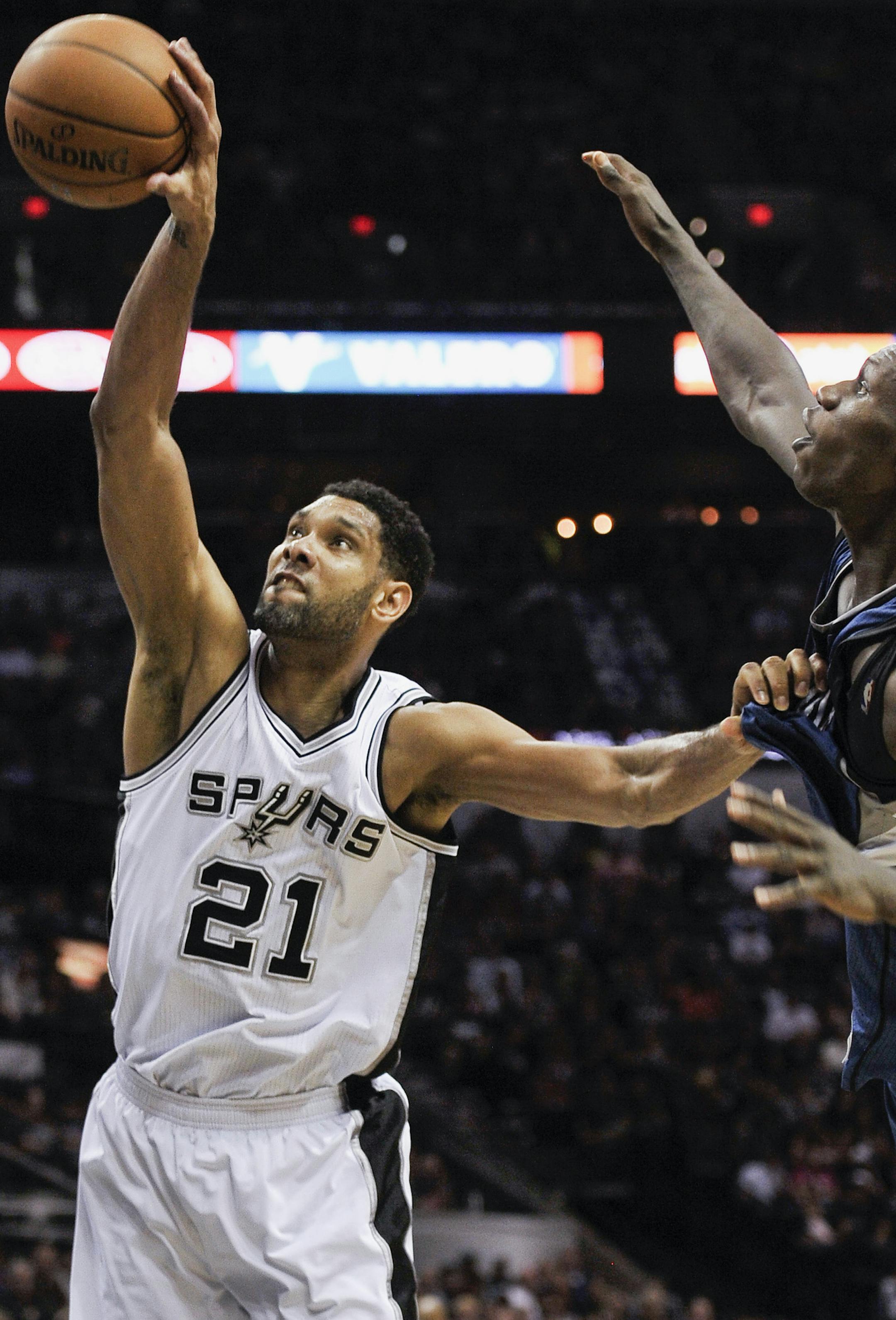 San Antonio Spurs forward Tim Duncan, left, grabs the rebound against Minnesota Timberwolves center Gorgui Dieng, of Senegal, during the second half of an NBA basketball game, Sunday, March 15, 2015, in San Antonio. San Antonio won 123-97. (AP Photo/Darren Abate)