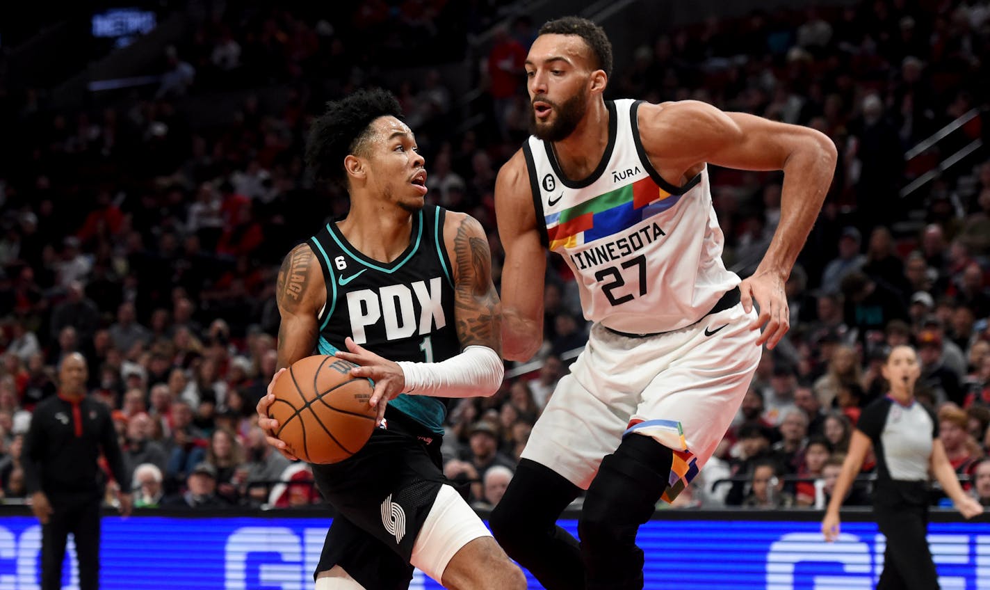 Portland Trail Blazers guard Anfernee Simons, left, drives against Minnesota Timberwolves center Rudy Gobert during the second half of an NBA basketball game in Portland, Ore., Saturday, Dec. 10, 2022. The Blazers won 124-118. (AP Photo/Steve Dykes)