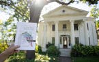 Richard Kronick held up the architectural history of Irvine Park disguised as a coloring book outside the 1851 Greek Revival house in Irvine Park (wit