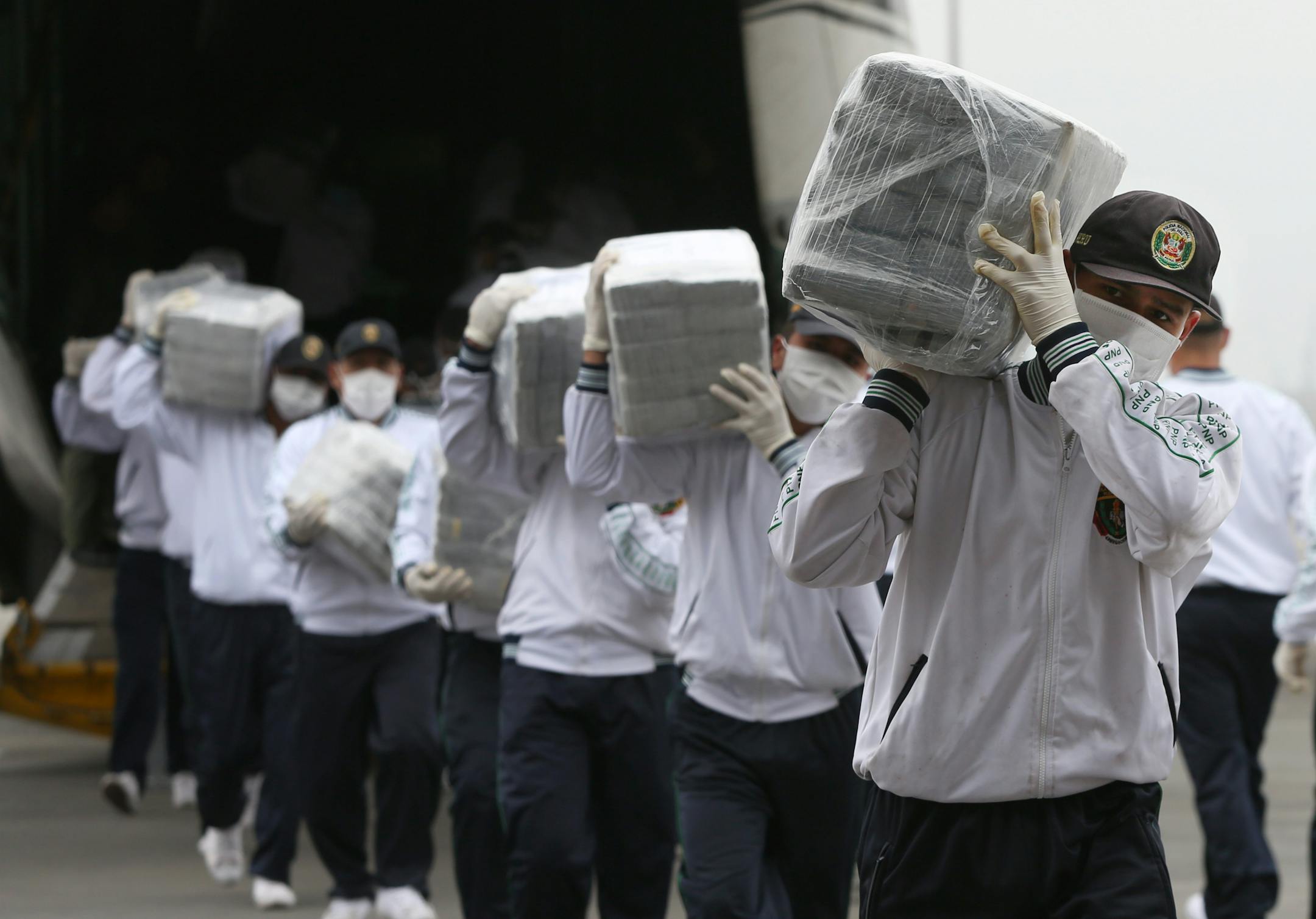 Police carried blocks of seized cocaine as they displayed it to the press at a police base in Lima, Peru, on Monday. Police announced that they seized 7.7 metric tons (8.5 tons) of cocaine in the northern town of Trujillo on Aug. 26, and that it's the largest seizure of cocaine in Peru's history.