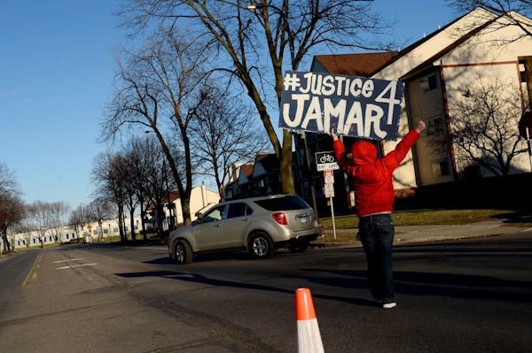 A protester waved a "Justice 4 Jamar" banner at traffic turning onto Plymouth Avenue on April 1.