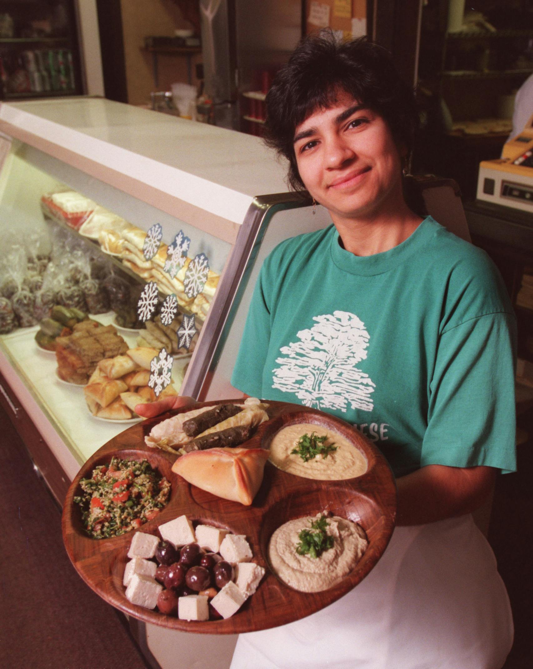 Amy Awaijane, part-owner of Emily’s Lebanese Delicatessen in Minneapolis, displays a few of the shops specialties including tabouleh, hummus, baba ghannuj, lamb and beef meat pie, greek olives, feta cheeze, cabbage rolls and grape leaf rolls.