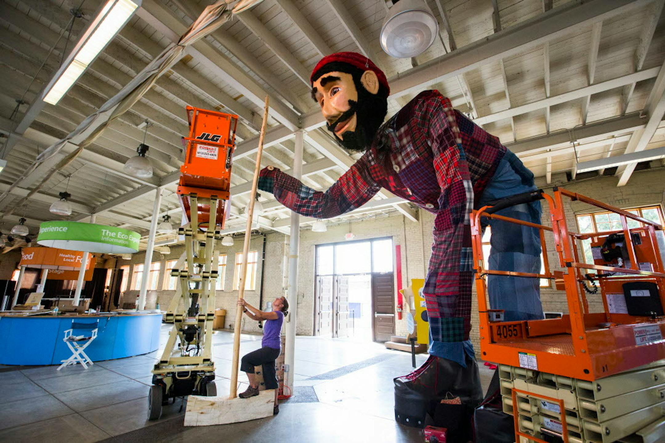 Jeanne Giernet of the Minnesota Pollution Control Agency sets up Paul Bunyan's axe, the handle of which is made from a small tree trunk and the blade carved with a chainsaw from a felled tree. ] (Leila Navidi/Star Tribune) leila.navidi@startribune.com BACKGROUND INFORMATION: Inside the Eco Experience Building at the Minnesota State Fairgrounds in Falcon Heights on Thursday, August 18, 2016. The Minnesota Pollution Control Agency will unveil at the State Fair a 20 foot tall Paul Bunyan dressed in