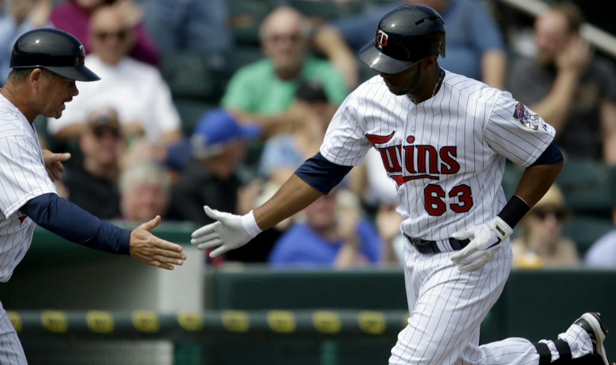 Aaron Hicks, right, got a high-five from third base coach Joe Vavra after hitting a home run.