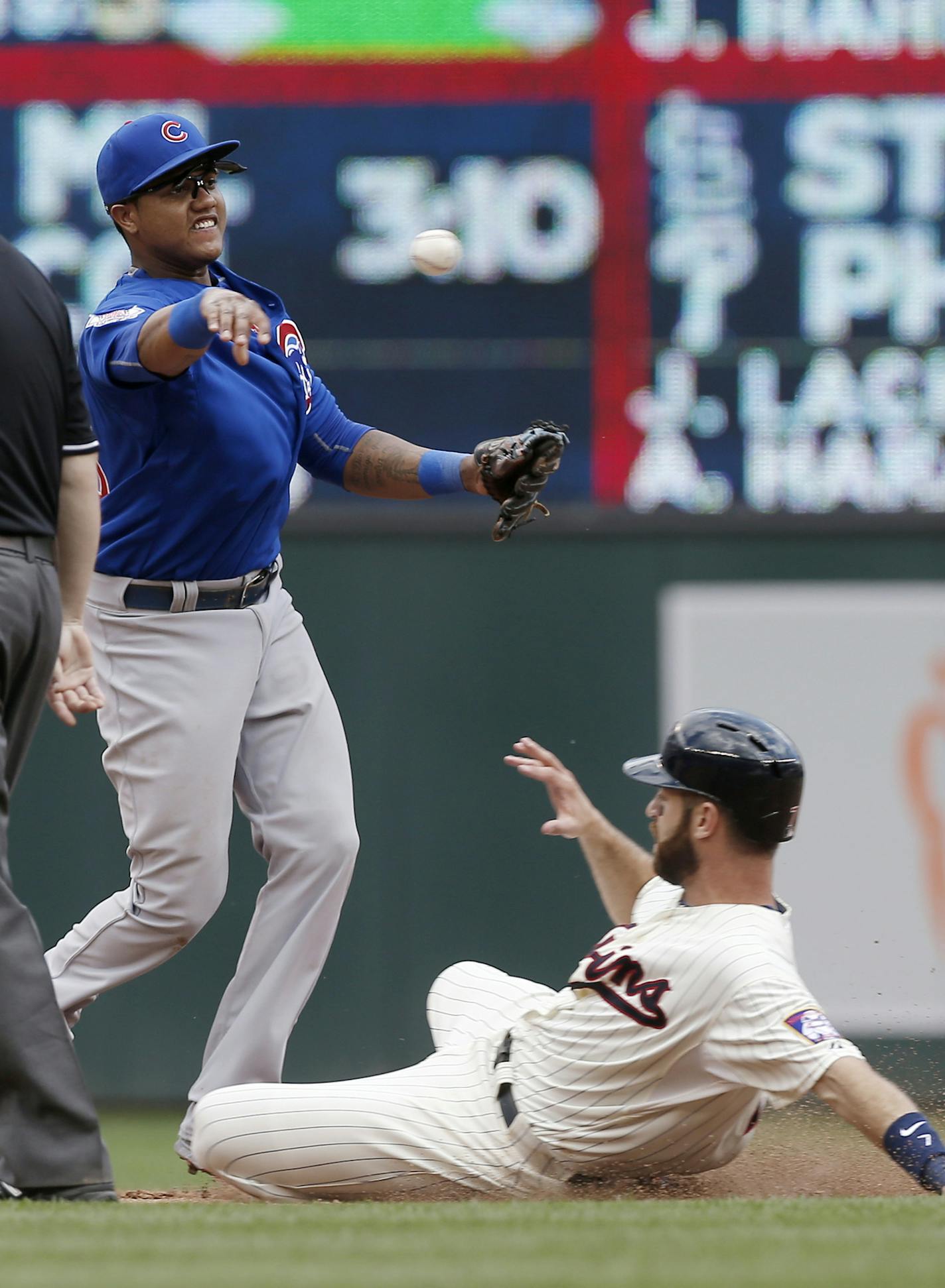 Chicago Cubs shortstop Starlin Castro, left, makes the double play throw on Minnesota Twins&#x2019; Trevor Plouffe after the force out at second of Joe Mauer, right, in the sixth inning of a baseball game, Saturday, June 20, 2015, in Minneapolis. Castro hit a two-run single in the 10th inning as the Cubs won 4-1. (AP Photo/Jim Mone)