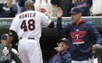 Minnesota Twins&#xed; Torii Hunter (48) is greeted at the dugout by manager Paul Molitor, right, and hitting coach Tom Brunansky, center, after hittin
