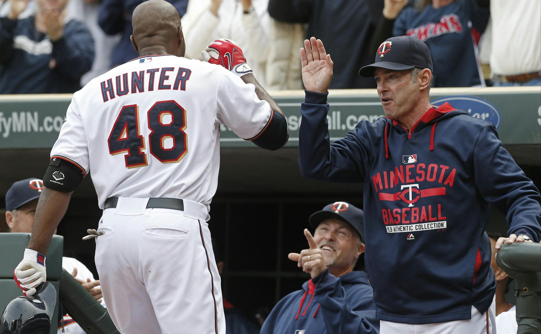 Minnesota Twins&#xed; Torii Hunter (48) is greeted at the dugout by manager Paul Molitor, right, and hitting coach Tom Brunansky, center, after hitting a three-run home run off Cleveland Indians relief pitcher Anthony Swarzak in the sixth inning of a baseball game, Sunday, April 19, 2015, in Minneapolis. The Twins won 7-2. (AP Photo/Jim Mone)