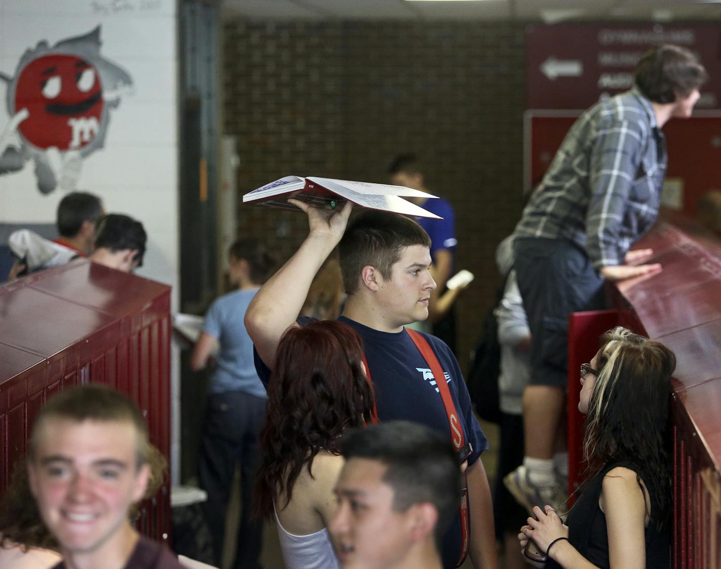 As fellow seniors chat and clean out their lockers, Seth Hult holds a year book he signed while searching for the owner Thursday, May 5, 2014, in North Branch, MN. Longer classes have benefited students in some classes, like science labs where they have longer to set up and break down during the class period.] (DAVIDJOLES/STARTRIBUNE) djoles@startribune.com With the district's financial crisis finally in the rearview mirror, the North Branch School District will end their four-day school week ex