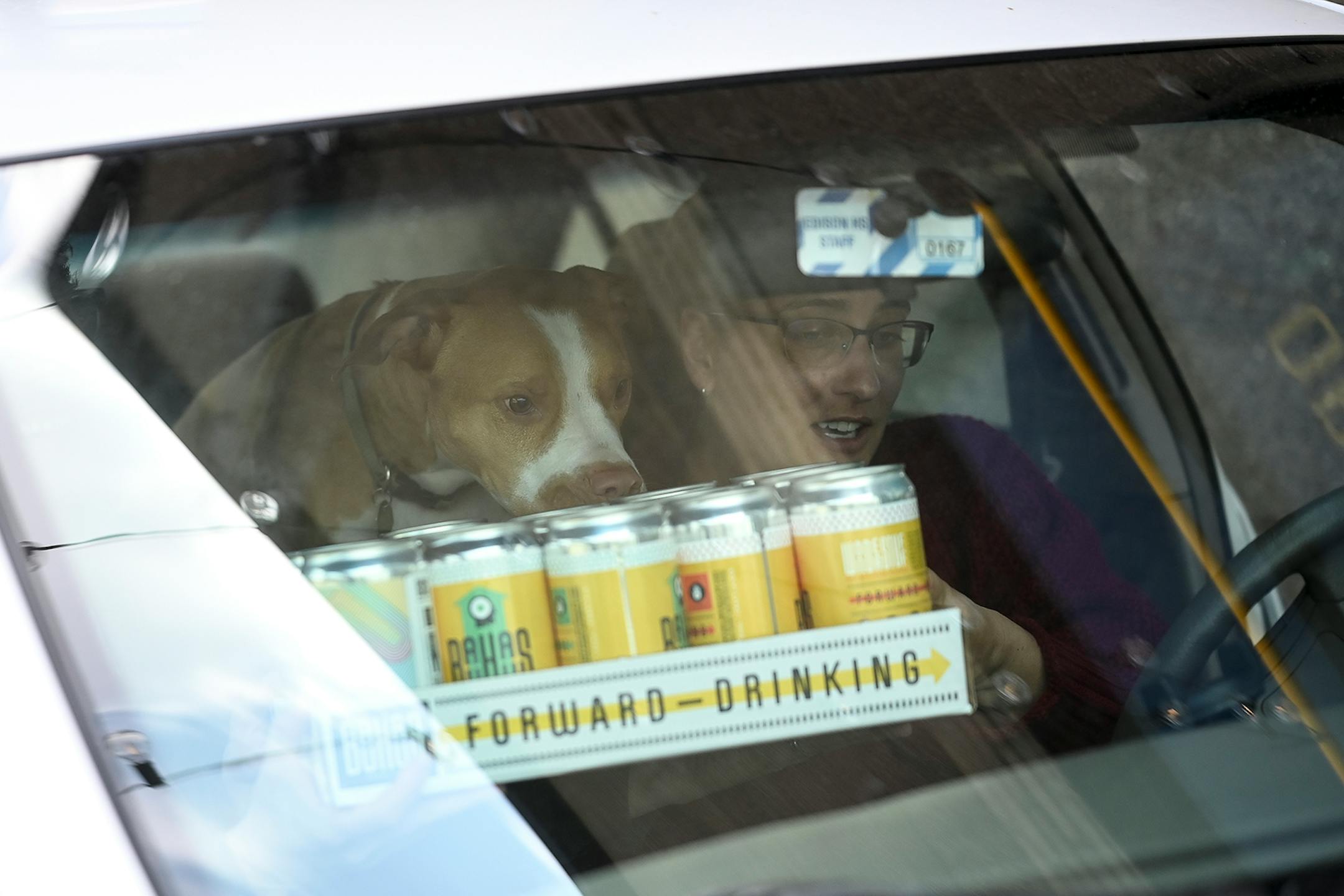 Krista Marino handed her husband, Paul, the beer crowlers they just purchased at Bauhaus as their dog, Birdie, sniffed their purchase. Despite strong sales of wine, spirits and beer in liquor stores since COVID-19 hit, craft breweries in Minnesota and other states have taken a body blow, especially the smaller breweries that produce less than 1,000 barrels annually.