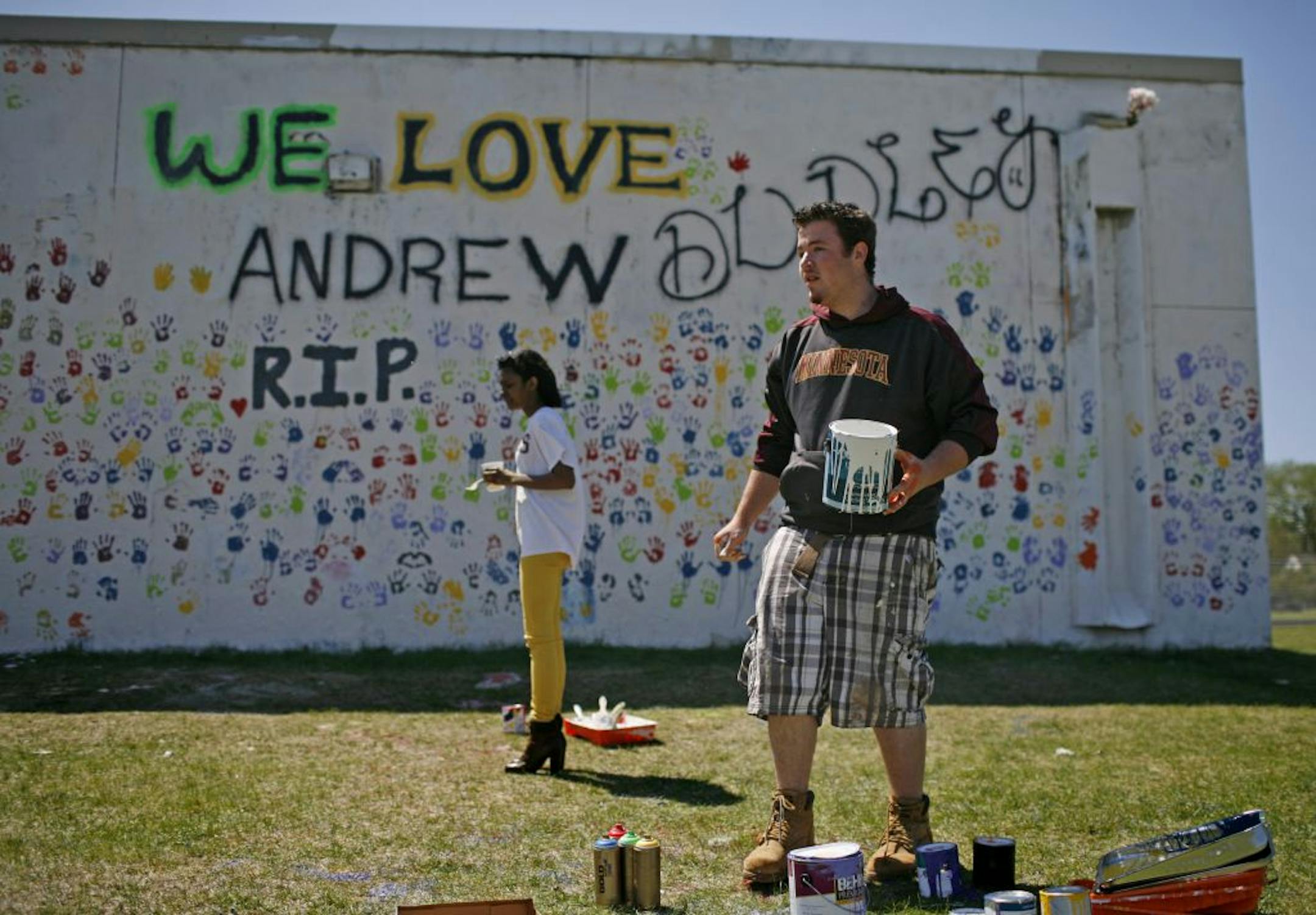 Students Sam Bristlin and Jessica Klass were among those who painted handprints on a memorial wall to remember their friend Andrew Dudley.