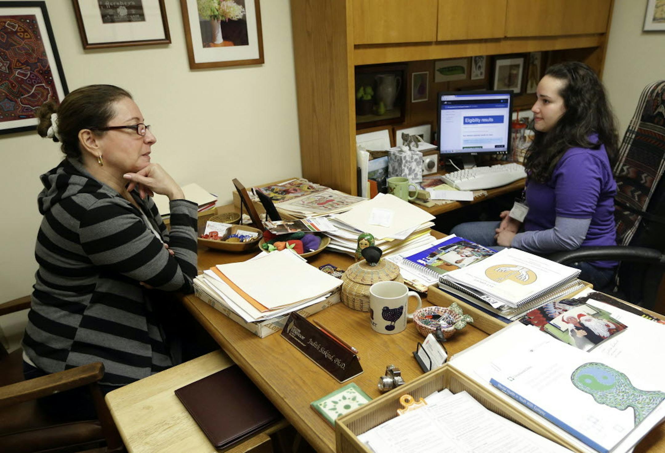 Jan. 8, 2014: Yolanda Madrid of Miami, left, talks with navigator Daniela Campos, right, while signing up for health insurance under the Affordable Care Act, in Miami. Mirroring problems with the federal health care website, people around the nation attempting to navigate the Spanish version have discovered their own set of difficulties.