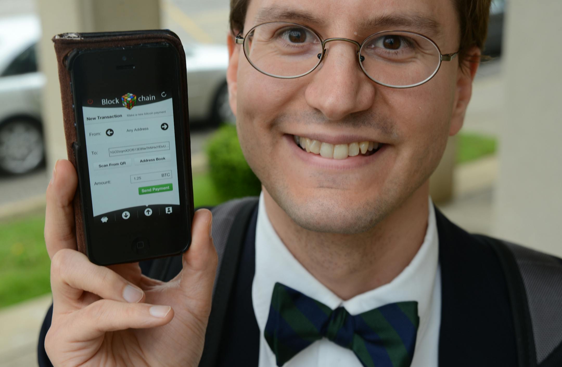 Brian Goss, a radiology resident in Rochester, holds an iPhone with the Bitcoin digital transaction form ready for a payment.