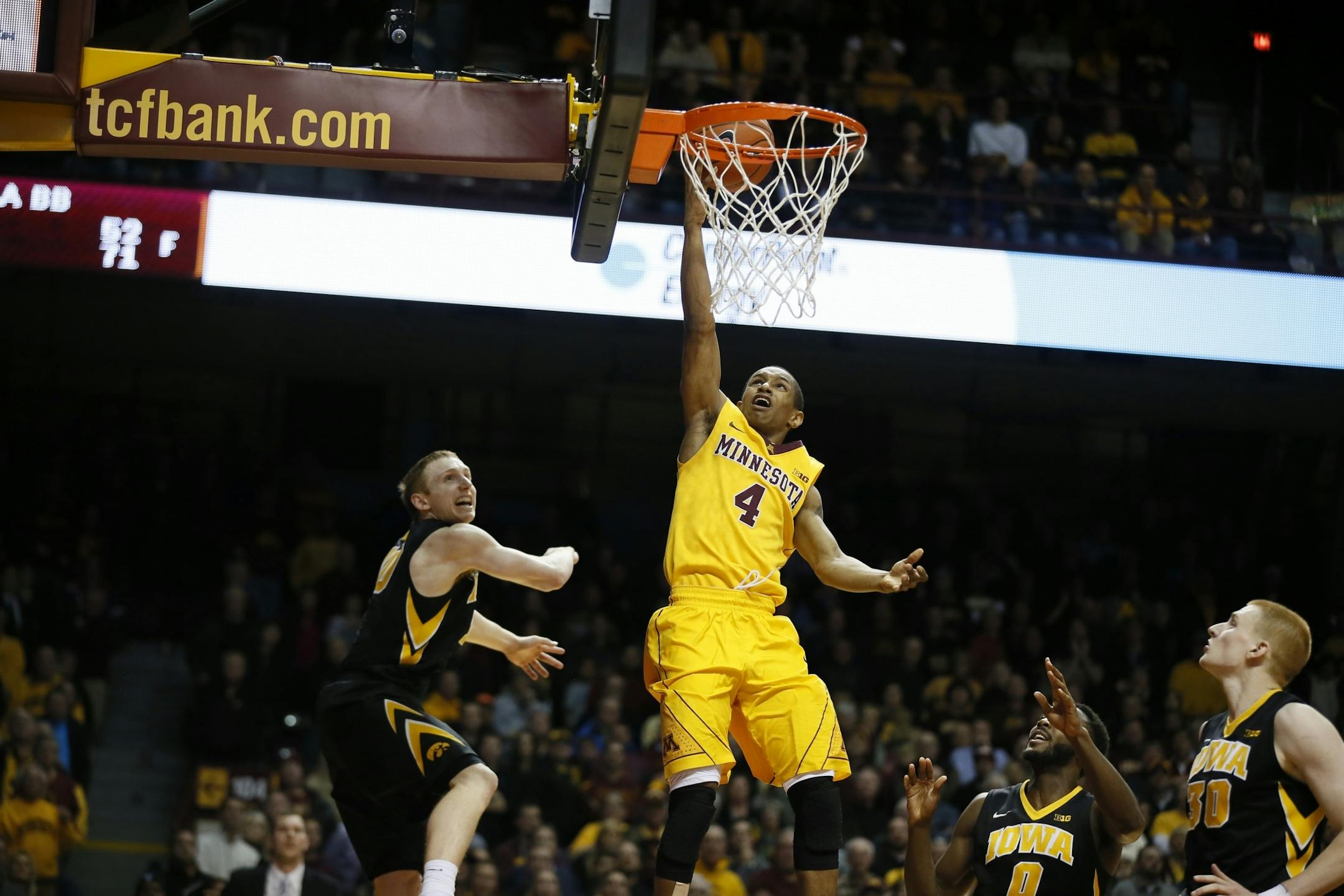 Minnesota Gophers guard DeAndre Mathieu (4) attempts his last-second shot on the Iowa defense. No time was left on the clock, and the Gophers lost 77-75.