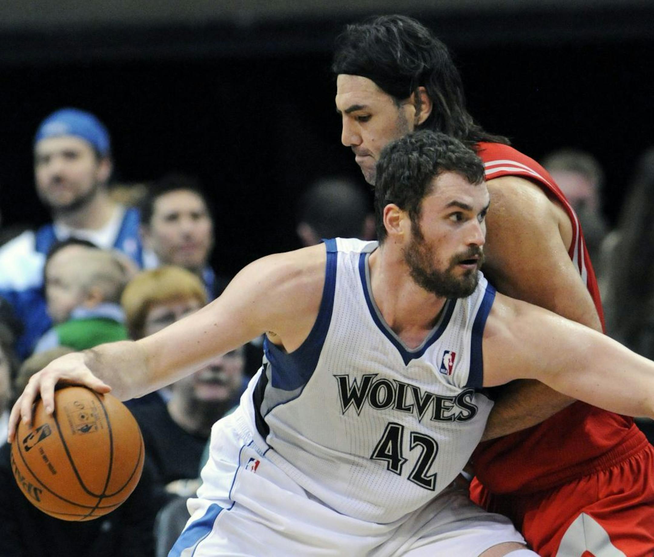 Minnesota Timberwolves' Kevin Love (42) drives around Houston Rockets' Luis Scola, of Argentina, in the second half of an NBA basketball game Saturday, Feb. 4, 2012, in Minneapolis. The Timberwolves won 100-91. Love led the Timberwolves with 25 points and 18 rebounds while Scola had 24 points for the Rockets.